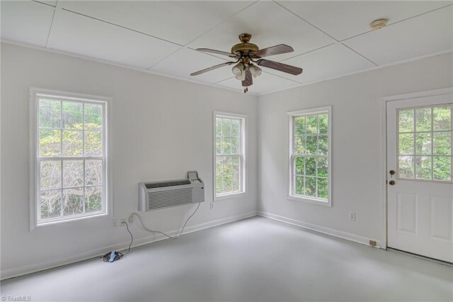 unfurnished living room featuring ceiling fan, an AC wall unit, and concrete flooring