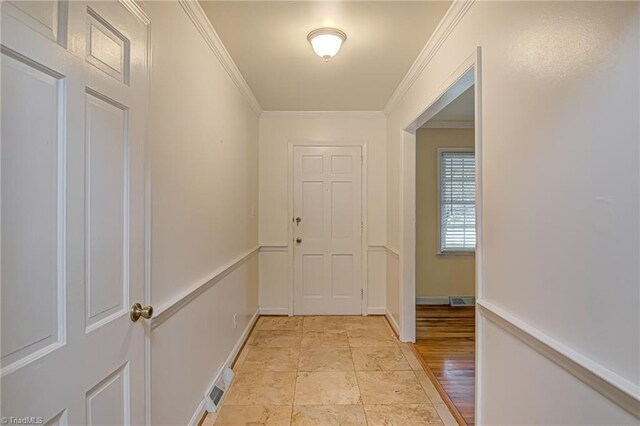 doorway to outside with ornamental molding and light hardwood / wood-style floors