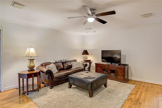 living room featuring light hardwood / wood-style flooring, ceiling fan, and ornamental molding