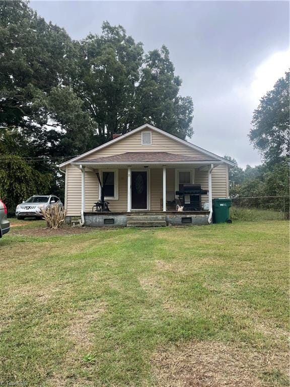 bungalow-style home featuring a front lawn and covered porch