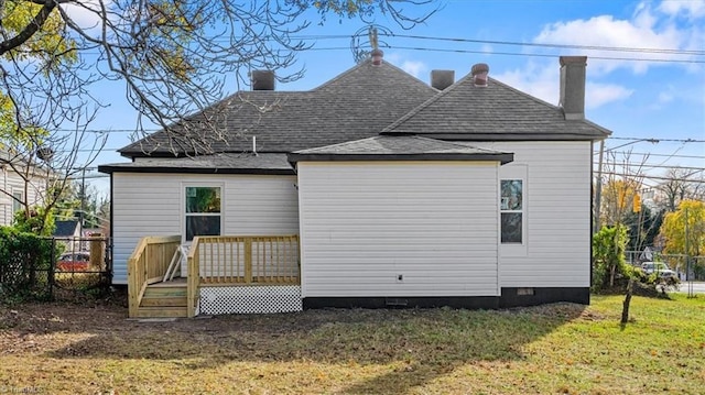 rear view of property featuring a yard and a deck