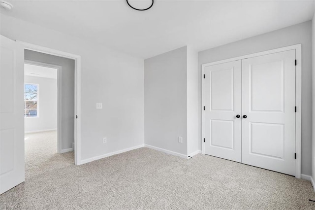 unfurnished bedroom featuring light colored carpet and a closet