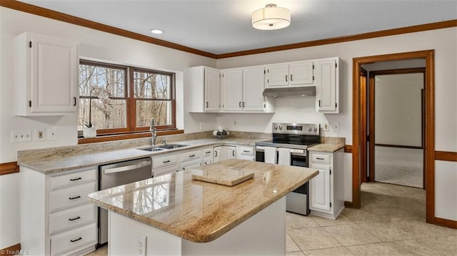 kitchen featuring light stone counters, appliances with stainless steel finishes, a kitchen island, and white cabinetry