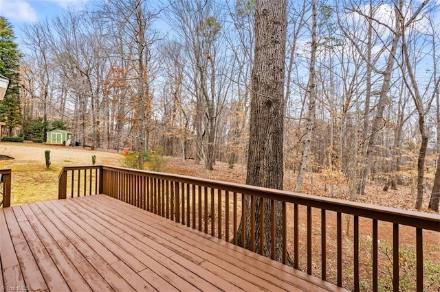 wooden terrace featuring a shed and an outdoor structure