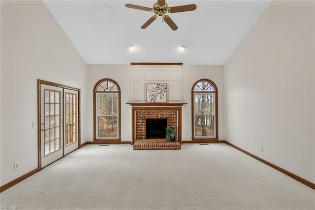 unfurnished living room featuring light carpet, baseboards, a ceiling fan, a fireplace, and high vaulted ceiling