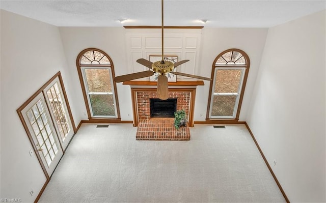 unfurnished living room with visible vents, a fireplace, light carpet, and baseboards