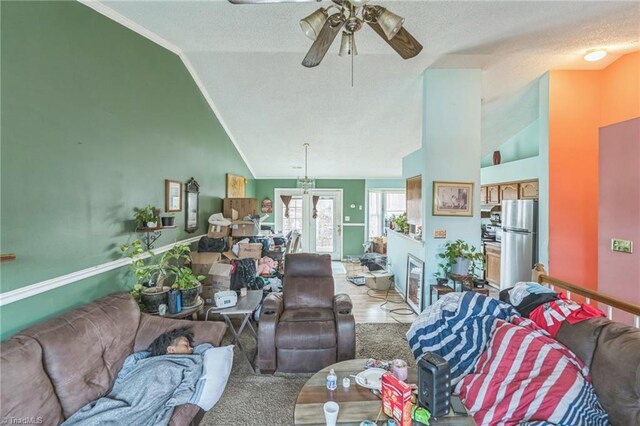 living room with a textured ceiling, ceiling fan, french doors, and lofted ceiling