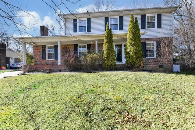 traditional home featuring a front lawn, a chimney, crawl space, and brick siding