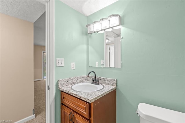 bathroom with vanity, a textured ceiling, and toilet