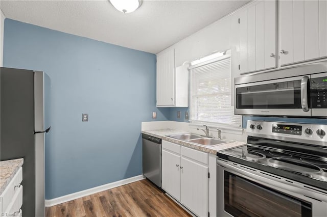 kitchen featuring stainless steel appliances, white cabinetry, sink, and dark hardwood / wood-style flooring