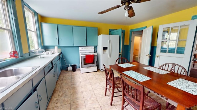 kitchen featuring white appliances, healthy amount of natural light, a ceiling fan, and light countertops
