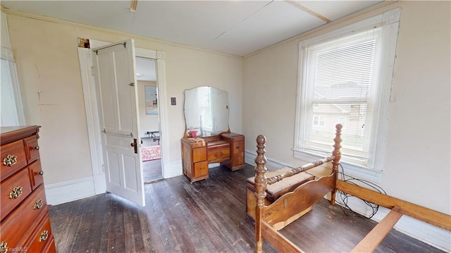 bedroom with dark wood-style floors, ornamental molding, and baseboards
