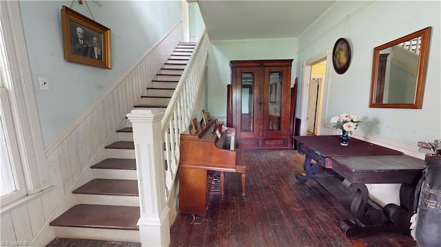entryway with stairway, hardwood / wood-style floors, a wainscoted wall, and ornamental molding