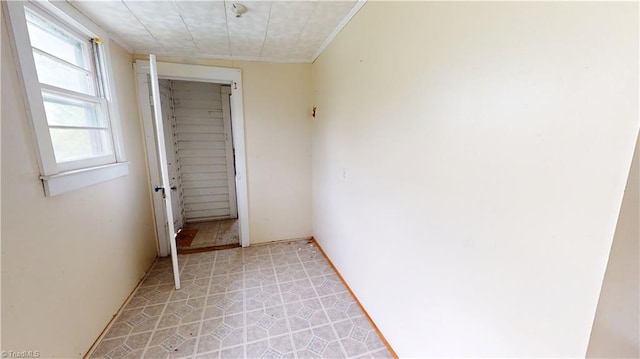 empty room with crown molding and light flooring