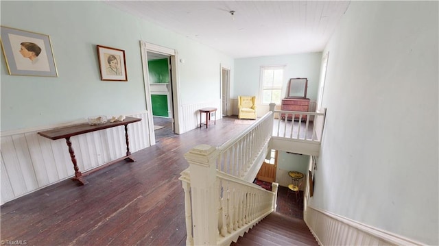 stairway featuring wood-type flooring and wainscoting