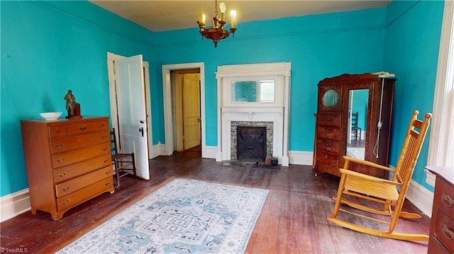 living room featuring hardwood / wood-style flooring, a chandelier, and baseboards
