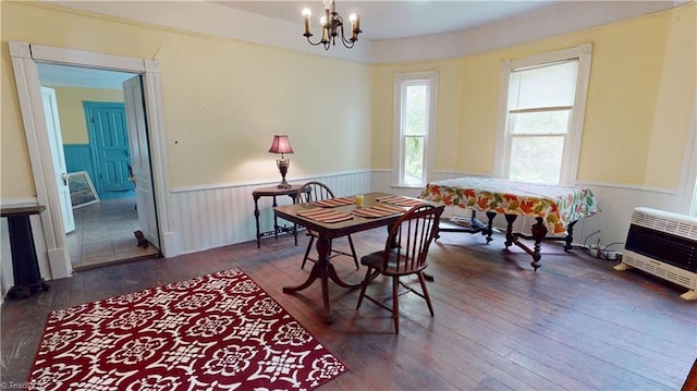 dining space with heating unit, wainscoting, a chandelier, and hardwood / wood-style floors