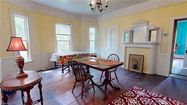dining space featuring a wainscoted wall, a chandelier, and dark wood finished floors