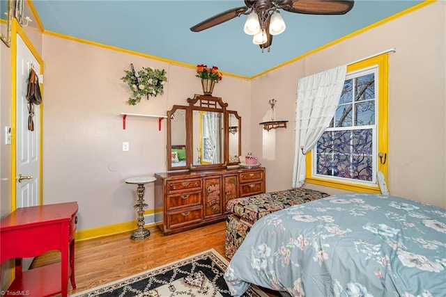 bedroom with ceiling fan, hardwood / wood-style floors, and crown molding