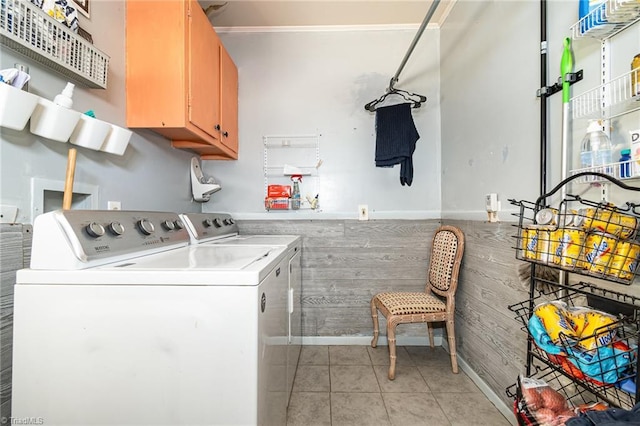 washroom with cabinets, washing machine and dryer, and light tile patterned floors