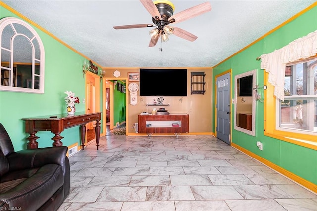 living room featuring ceiling fan, a textured ceiling, and crown molding