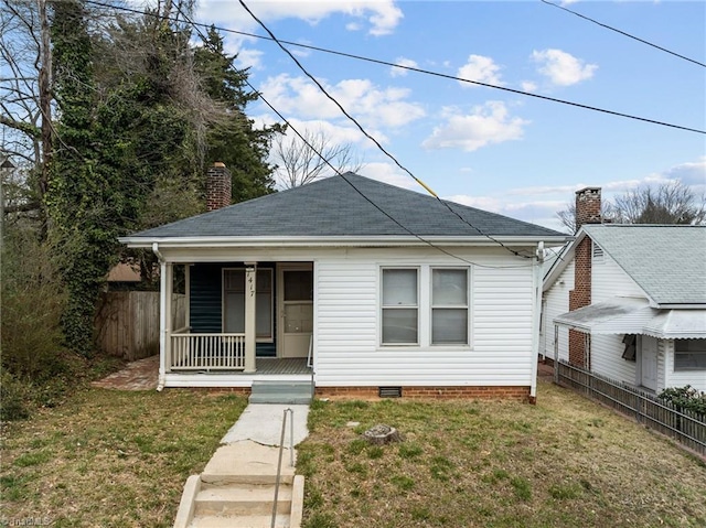 bungalow-style house with a front yard, covered porch, fence, and crawl space