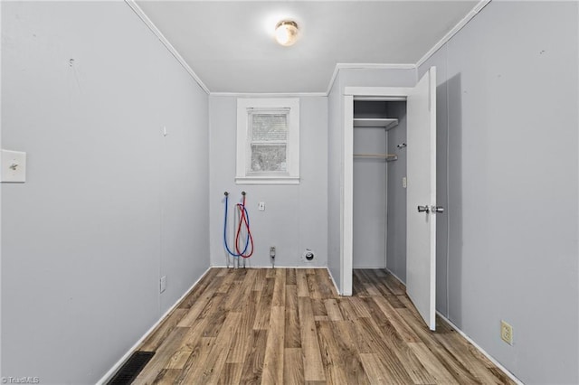 clothes washing area with laundry area, wood finished floors, visible vents, and crown molding