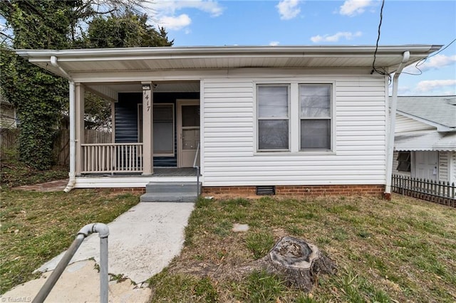 view of front of house with a front yard, crawl space, covered porch, and fence