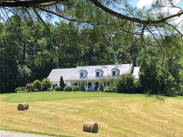 cape cod home featuring a front lawn