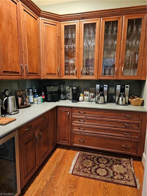 kitchen with backsplash, wine cooler, and light hardwood / wood-style flooring