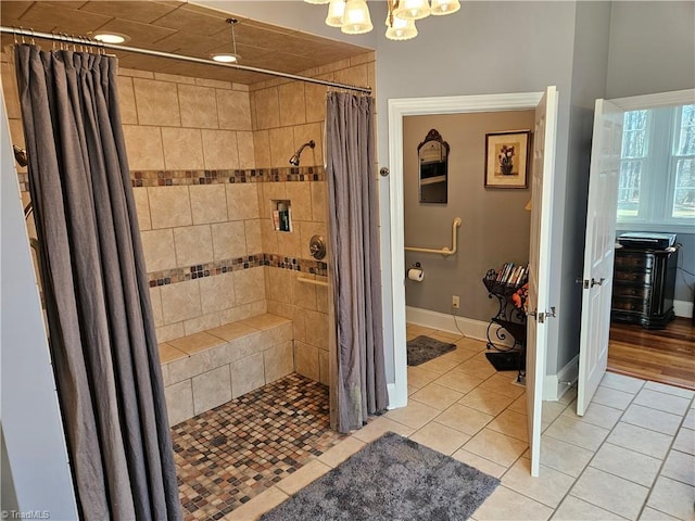 bathroom featuring an inviting chandelier, tile flooring, and a shower with curtain