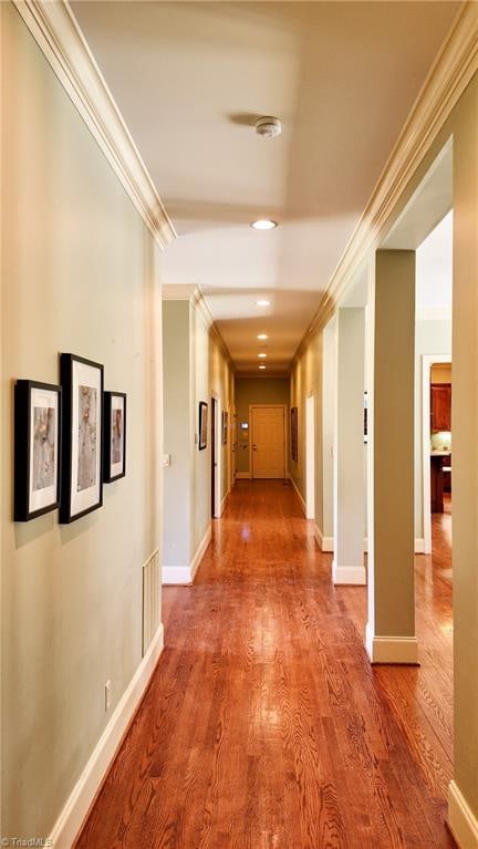 corridor with ornamental molding and dark hardwood / wood-style floors