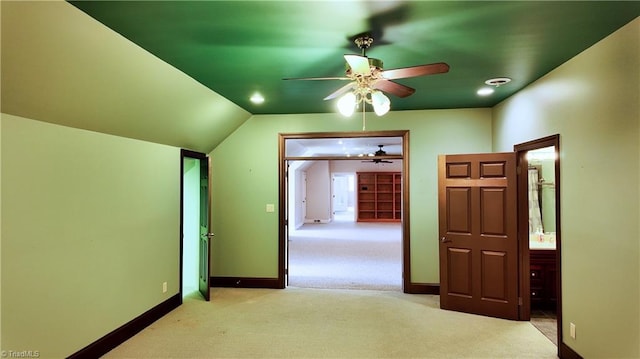 interior space featuring light colored carpet, vaulted ceiling, and ceiling fan