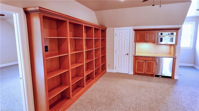 interior space featuring ceiling fan, lofted ceiling, and light colored carpet