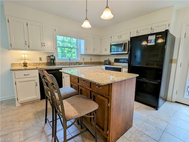 kitchen with pendant lighting, black appliances, white cabinets, sink, and a kitchen island