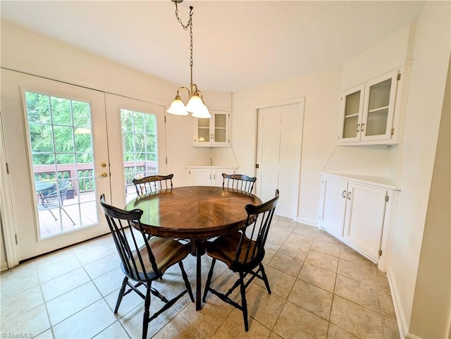 dining area with french doors, light tile patterned floors, and a notable chandelier