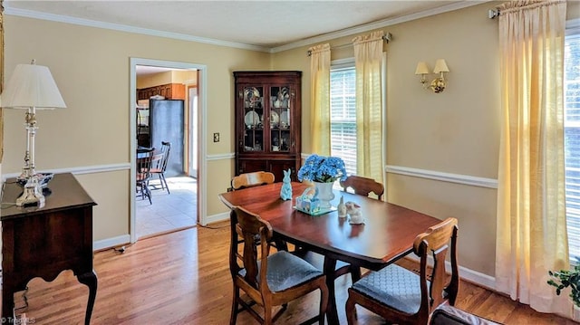 dining space featuring crown molding and light hardwood / wood-style flooring