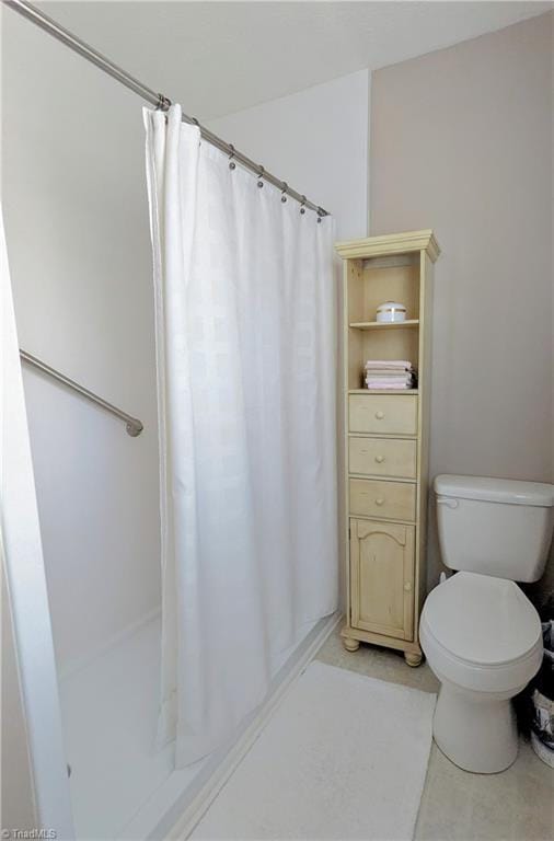 bathroom featuring a shower with shower curtain and toilet