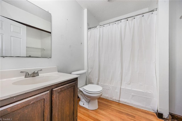 full bathroom with wood-type flooring, toilet, a textured ceiling, vanity, and shower / tub combo