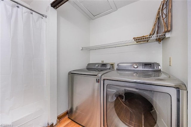 laundry area featuring independent washer and dryer and light hardwood / wood-style flooring