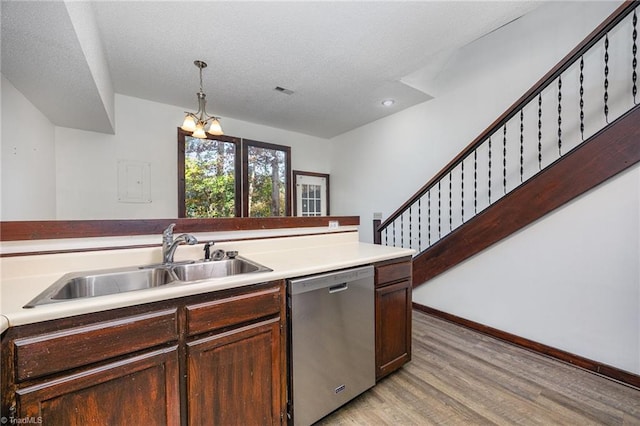 kitchen featuring light wood-type flooring, decorative light fixtures, sink, an inviting chandelier, and stainless steel dishwasher