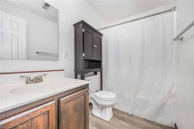 bathroom with toilet, vanity, and hardwood / wood-style flooring