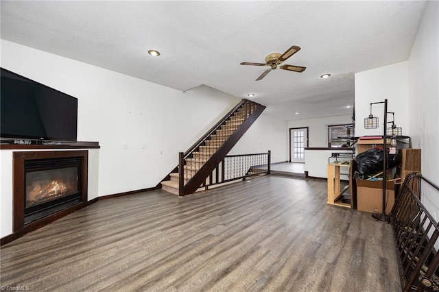 living room featuring a textured ceiling, hardwood / wood-style flooring, and ceiling fan