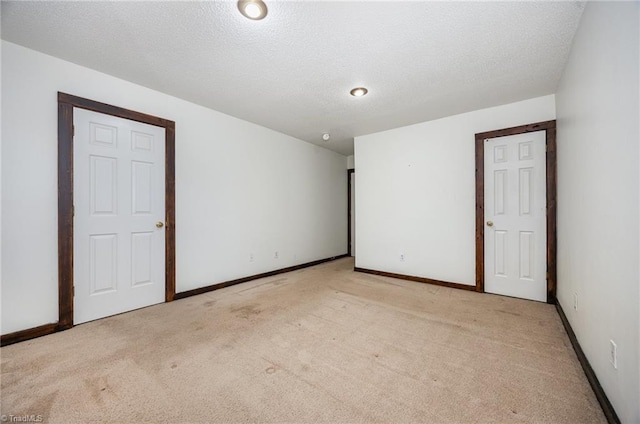 empty room featuring light colored carpet and a textured ceiling