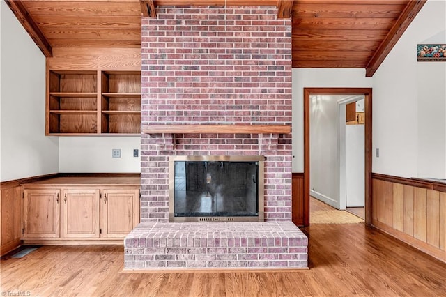 unfurnished living room featuring light wood-type flooring, a brick fireplace, wood ceiling, lofted ceiling, and wood walls