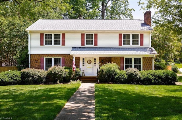 3600 Spicebush Trl, Greensboro, NC 27410 - traditional-style home with a chimney, a front yard, brick siding, and roof with shingles