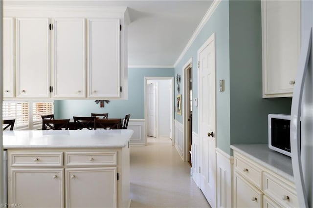 3600 Spicebush Trl, Greensboro, NC 27410 - kitchen with white appliances, light countertops, crown molding, a wainscoted wall, and a decorative wall