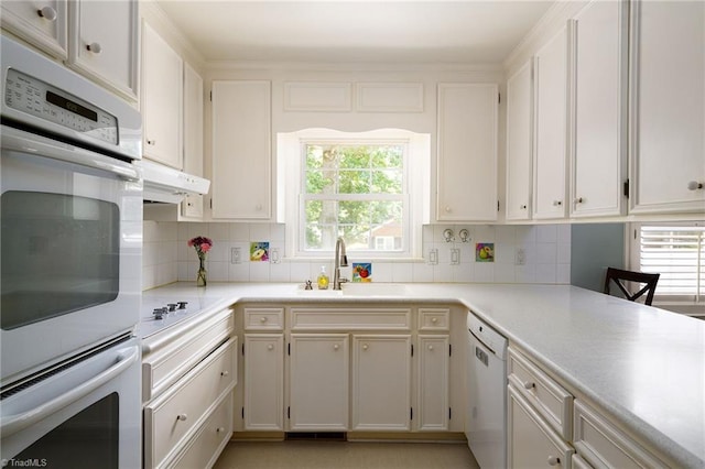 3600 Spicebush Trl, Greensboro, NC 27410 - kitchen with white dishwasher, under cabinet range hood, backsplash, and light countertops