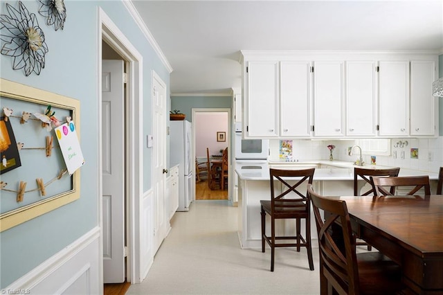 3600 Spicebush Trl, Greensboro, NC 27410 - kitchen featuring white appliances, light countertops, white cabinetry, and crown molding