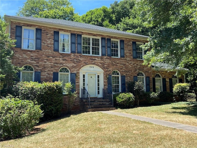 colonial inspired home featuring a front yard